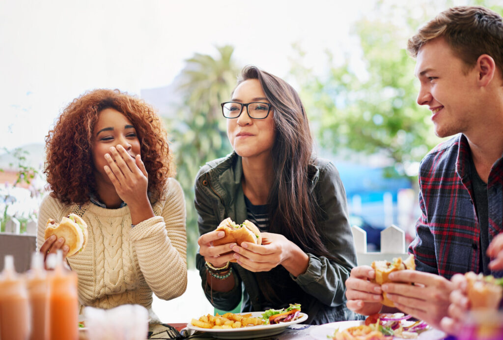 Freunde essen gemeinsam in ihrer Freizeit Burger