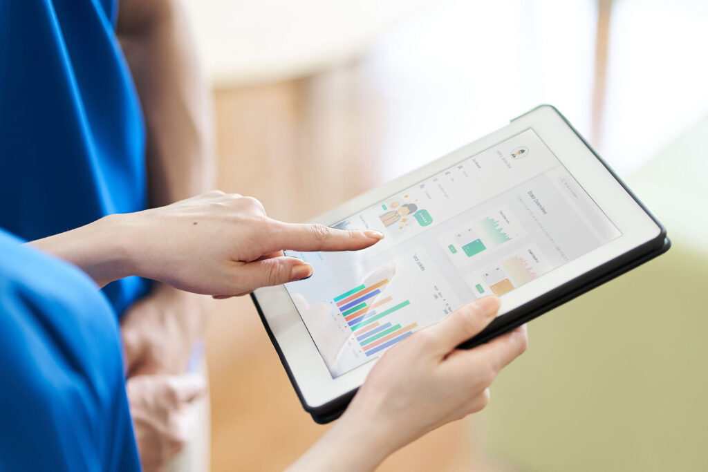 Pflegekraft zeigt auf Tablet mit digitalen Daten
